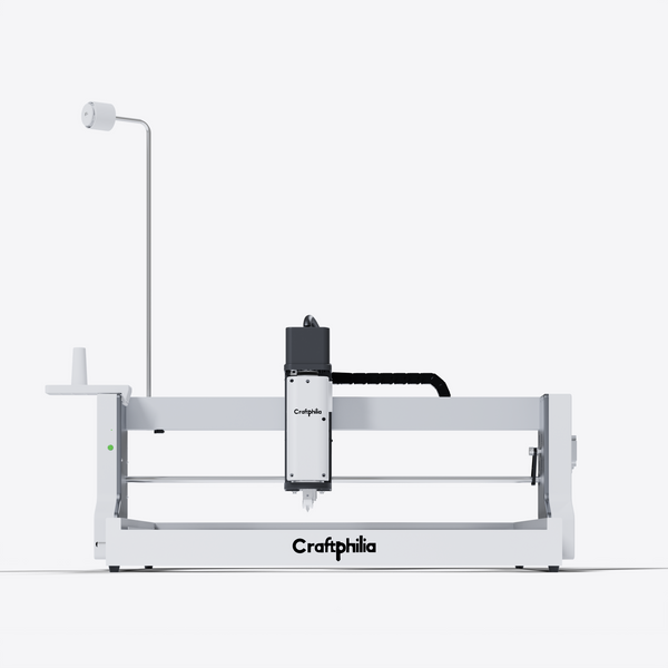 A Craftphilia 50cm*50cm desktop Automatic tufting machine shown in a clean studio shot against a light gray background. The Automatic tufting machine features a white metal frame with a black and white gantry system holding the print head.